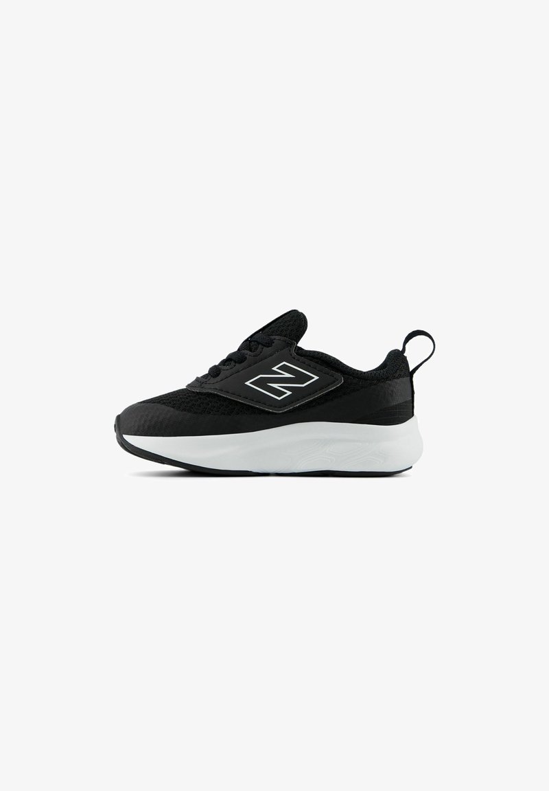 Botte de sport noire avec un upper texturé, semelle intermédiaire blanche, lacets et une boucle au talon. Présente un logo bien visible sur le côté.