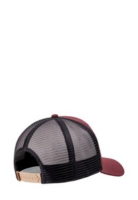 Gorra trucker de malla en color marrón y negro con correa ajustable de snaps en beige, mostrada desde la parte trasera y lateral sobre un fondo blanco.