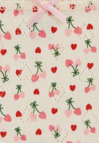 A gyapjúszövet krémszínű alapon rózsaszín és piros cseresznye és szív mintákkal, amelyeket kis zöld szárak és egy rózsaszín masni díszítenek.