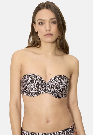 Mujer con cabello largo y castaño que lleva un top de bikini sin tirantes con un estampado de formas abstractas en negro y rosa claro sobre un fondo liso.