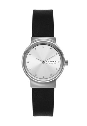Minimalistische Skagen-Armbanduhr mit silbernem rundem Zifferblatt, Kristall-Stundenmarkierungen, schlanken Zeigern und schwarzem Lederarmband.