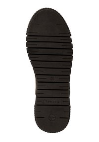 Suela de zapato de goma negra con ranuras horizontales y verticales, etiquetada con la talla 37. Superficie texturizada para agarre y estabilidad.