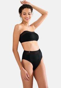 Bikini top noir sans bretelles avec une finition transparente et un bas taille haute. Texture lisse avec un design minimaliste et des détails en métal argenté.