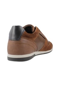 Sneaker in pelle marrone con dettagli in suede, superficie texturizzata, suola bianca e cappuccio del tallone scuro; presenta un design a profilo basso.