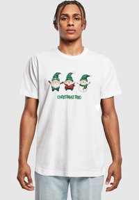Hvid bomulds t-shirt med et print af tre nisser med grønne hatte og en snemænd med røde og grønne accenter. Tekst: "JULETRIO" i grønt.