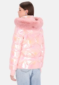 Różowa kurtka puchowa o błyszczącym, pikowanym wykończeniu z kapturem wykończonym sztucznym futrem. Posiada ściągacze na mankietach i luźny krój.