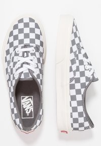 Svartvita rutiga Vans-sneakers med vita snören, gummisulor och synlig Vans-logotyp inuti samt på hälfliken.