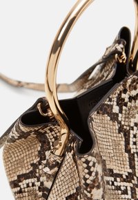 Sac à main structuré avec un motif en peau de serpent dans des nuances de brun et beige, équipé de ferrures métalliques dorées et d'une anse proéminente.