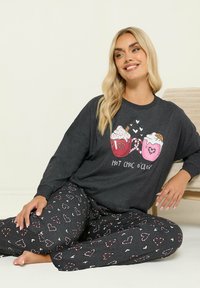 Ciemnoszara piżama składająca się z długiego rękawa z graficznymi kubkami gorącej czekolady oraz wzorzystych serc na zwężających się spodniach. Miękki materiał.
