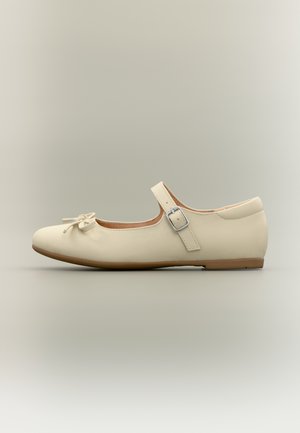 Beige balletsko med rund tå, bånddetalje foran og justerbar rem med sølvspænde. Glat lædertekstur.