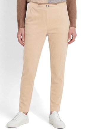 Beige rechte broek met een klein ceintuurdetaillering, gedragen met witte sneakers en een tweekleurige bruine gebreide trui.