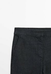 Pantalon en denim foncé avec une texture lisse, une coupe droite, des coutures visibles et des poches avant. Le tissu est léger et flexible.