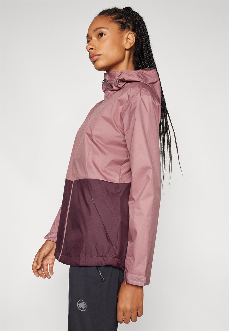 Veste légère et imperméable avec un dessus rose et un bas bordeaux foncé. Comprend une capuche, une fermeture éclair et des poignets élastiques.