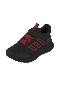 Zapatilla deportiva negra con acentos rojos; presenta una parte superior de malla con una correa de Velcro, suela texturada y tres franjas características en el costado.
