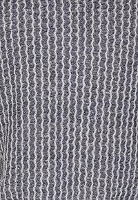 Laivastonsininen ja valkoinen kuvioitu kangas, jossa on aaltoileva muotoilu ja teksturoidut poimutetut linjat, luoden kosketeltavan, kerroksellisen ilmeen.