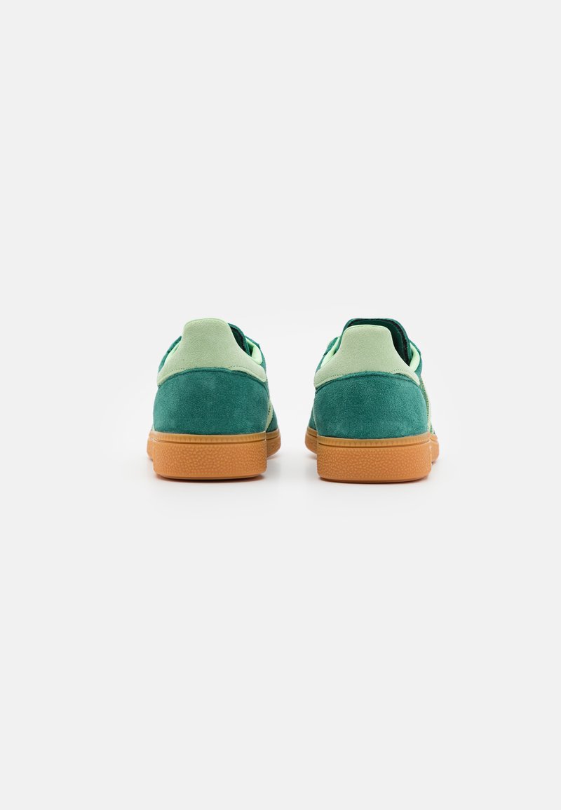 Sneakers verdi in suede con una superficie testurizzata, dotate di un tallone verde chiaro e una suola in gomma. Progettate con profilo basso.