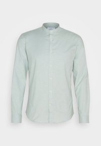Chemise homme manches longues vert clair avec col mao et fermeture boutonnée devant.