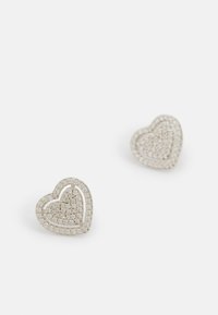 Silver hjärtformade örhängen med en strukturerad yta; omramade av en glänsande kant, prydda med små glittrande detaljer.