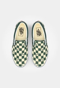Grüne und cremefarbene Schachbrett-muster Slip-On Vans-Schuhe mit Logo-Details, weißen Sohlen und einer glatten Textiloberfläche.