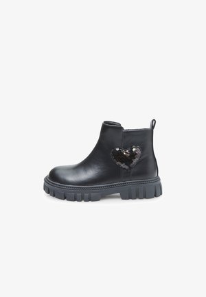 Botas de tobillo de cuero negro con una suela gruesa gris, que presentan un acento de lentejuelas en forma de corazón en el costado. Textura suave, diseño de punta redonda.