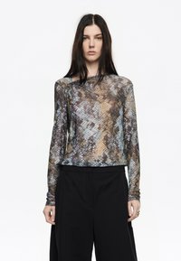 Langsleeve, doorzichtige top in bruin en blauw met een gestructureerd diamantpatroon. Heeft een enkele schoudernaaddetail.