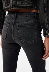 Sorte denim jeans med fem-lomme design, som har en tætsiddende pasform og diskret falming. Teksturen ser glat og holdbar ud.