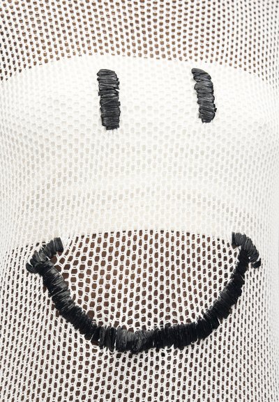 Λευκό ύφασμα από δίχτυ με μαύρο κεντημένο χαμογελαστό πρόσωπο, που δείχνει δύο κάθετα μάτια και ένα φαρδύ καμπυλωτό στόμα.