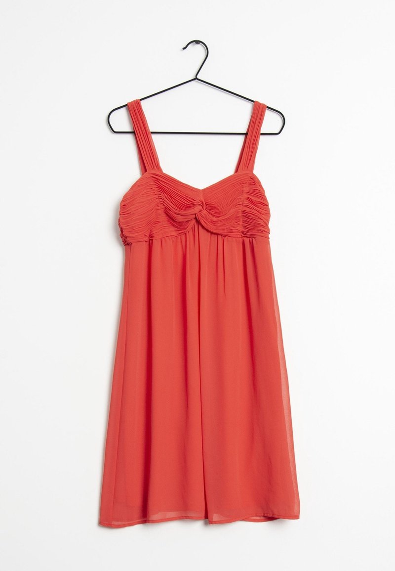Robe corail sans manches avec un buste froncé et de larges bretelles, suspendue à un cintre noir sur fond blanc.