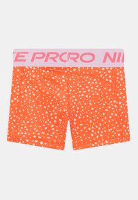 Orange Sportshorts mit weißen Pünktchen, einem rosa elastischen Bund mit dem "Nike Pro"-Logo und einer figurbetonten Passform.