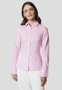 Różowa lniana koszula o dopasowanym kroju, z długimi rękawami i zapinana na guziki. Posiada klasyczny kołnierzyk i gładką fakturę.