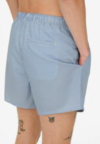 Pantalones cortos a rayas azules con una cintura elástica, bolsillos laterales y un bolsillo trasero con un detalle de ribete en contraste.