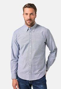 Helles blaues kariertes Hemd mit Knöpfen, ausgestattet mit Kragen, langen Ärmeln und einer Brusttasche; weiche Textur, aus Baumwollstoff.