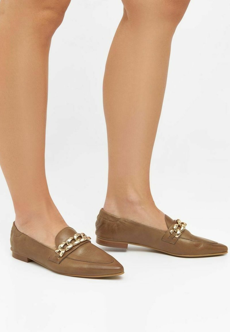 Brune læder loafers med spidse tæer, med en guldkæde detalje og flad hæl. Teksturert rygpanel og glat front.