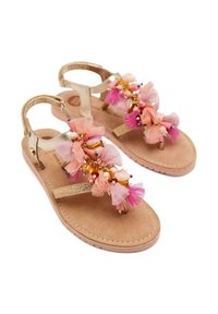 Sandalias doradas con una suela acolchada color tostado, adornadas con flores de tul en tonos rosa y púrpura, cuentas y detalles decorativos en las correas.