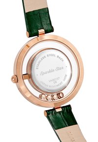 Reloj de oro rosa con fondo de acero inoxidable; correa de cuero verde; forma redonda; cuenta con una caja de vidrio transparente y movimiento visible.