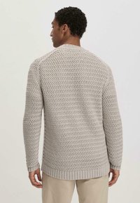 Beige Strickpullover mit einem strukturierten Zickzackmuster, gerippten Bündchen und Saum, mittellangen Ärmeln und Rundhalsausschnitt.