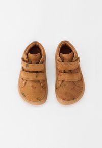 Braune Wildlederschuhe mit zwei verstellbaren Klettverschlussriemen. Sie verfügen über bunte, kleine Muster auf dem Obermaterial und eine Gummisohle. Rund geschnittene Zehenpartie.