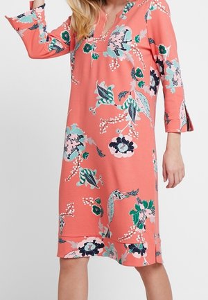 Robe corail avec un col en V et des manches trois-quarts, présentant un motif floral en bleu, vert et noir. Tissu doux et lisse.