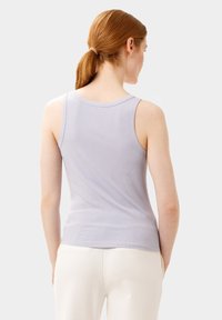 Jasnolawendowy, bezrękawnik o rypsowanej teksturze, dopasowany fason, z okrągłym dekoltem i szwami na ramionach.