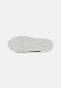 White shoe sole with curved, textured grip patterns and a "Levi's" logo embossed near the heel area.