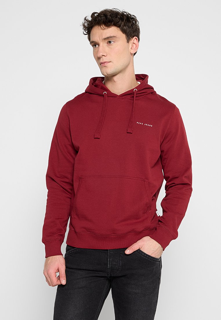 Sudadera burdeos con cordón, bolsillo canguro frontal y un detalle sutil del logo. Material suave, corte casual, con puños y dobladillo de canalé.