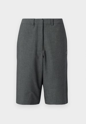 Pantaloni corti grigio scuro su misura con tessuto testurizzato, piega frontale singola, passanti per cintura, tasche laterali e un piccolo logo sul lato.
