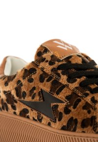 Sneaker con stampa leopardata e texture pelosa, dettagli in gomma nera e pannello in pelle marrone con logo. Suola spessa in gomma con scanalature.