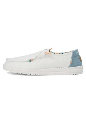 White fabric slip-on shoe with textured design, blue back panel, orange and green accents, and patterned interior lining. Rubber sole.