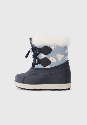 Botte d'hiver enfant avec semelle en caoutchouc bleu marine, dessus en tissu bleu décoré d'ours polaires, garniture en fausse fourrure blanche et fermeture à lacets sur fond blanc.