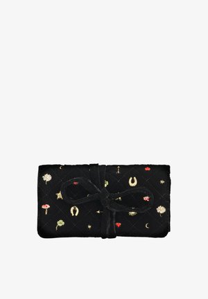 Czarna pikowana tkanina pokrowiec z wyszywanymi szczęśliwymi symbolami, związany kokardą z dopasowanej tkaniny.