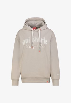 Hellbeiger Hoodie mit weißen Kordeln, roten Akzenten und weißem Text „oui chérie C'est possible.“ auf der Vorderseite gedruckt. Gerippte Bündchen und Saum.