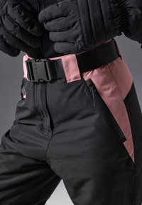 Black snow pants with pink accents, adjustable waistband, side zip pockets, and padded fabric, suitable for cold weather activities.
