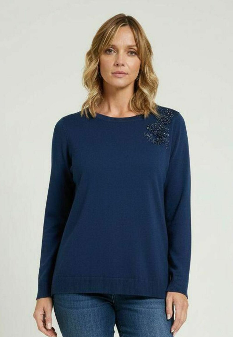 Marineblauer Pullover mit rundem Ausschnitt, langen Ärmeln und strukturiertem Detail mit Verzierungen auf einer Schulter. Weicher Stoff, figurbetontes Design.