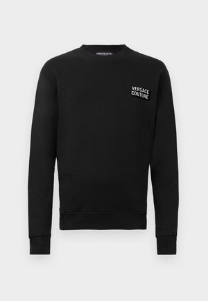 Sort sweatshirt lavet af bomuld med lange ærmer, ribstrikkede manchetter og rund halsudskæring. Har et hvidt broderet "Versace Couture" logo på brystet.